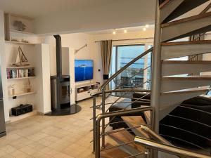 ein Wohnzimmer mit einer Wendeltreppe und einem Kamin in der Unterkunft Villa View- Grapevines Villas - your sea view vacation in Makry Gialos