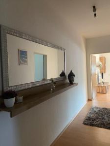 um espelho numa parede numa sala de estar em TOP Apartment für bis zu 4 Personen em Bad Oeynhausen