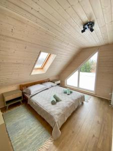 ein Schlafzimmer mit einem großen Bett und einem großen Fenster in der Unterkunft Mielno Woodhouse in Mielno