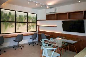 ein Konferenzraum mit Tisch und Stühlen und Fenstern in der Unterkunft Monoambiente CasArte Takubamba in Santa Cruz de la Sierra