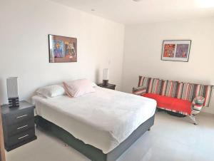 ein Schlafzimmer mit einem großen Bett und einem Stuhl in der Unterkunft Monoambiente CasArte Takubamba in Santa Cruz de la Sierra + 8 Fotos