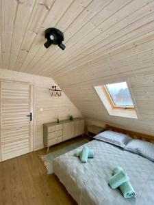 Schlafzimmer mit einem Bett und einer Decke mit einem Fenster in der Unterkunft Mielno Woodhouse in Mielno