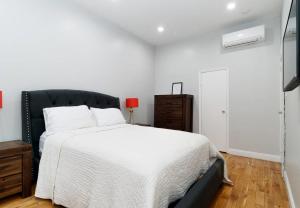 a bedroom with a white bed and a black headboard at Gorgeous 2 Bedroom apartment in NYC! in New York
