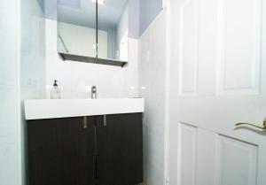 a white bathroom with a sink and a mirror at Gorgeous 2 Bedroom apartment in NYC! in New York