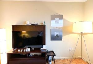 een woonkamer met een grote televisie en een lamp bij Gorgeous 2 Bedroom apartment in NYC! in New York