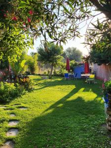 a garden with a table and chairs in the grass at Maison avec jardin arboré in Saint-Nazaire