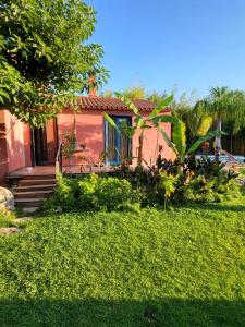 a small red house with a porch and a yard at Maison avec jardin arboré in Saint-Nazaire