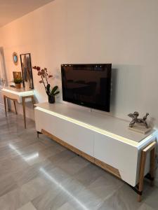 a flat screen tv sitting on top of a white entertainment center at Apartamento Mi Capricho in Sitio de Calahonda