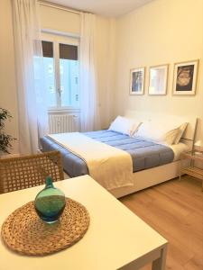 Un dormitorio con una cama y una mesa con un jarrón. en Politecnico Bovisa university apartment en Milán