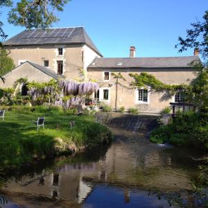 una casa con un río delante de ella en le gîte au pied des chevaux en Baugé-en-Anjou