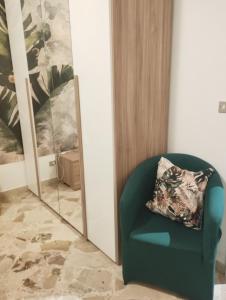 zielone krzesło z poduszką przed lustrem w obiekcie Casa Giorgia w Cefalù