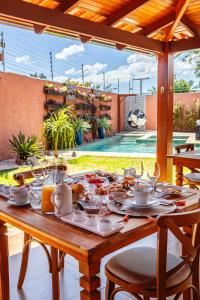 uma mesa com comida e uma piscina em Pousada Vila Rica em Pirenópolis