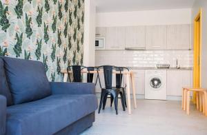 a living room with a couch and a table with chairs at Apartamentos surfing San Vicente II in San Vicente de la Barquera