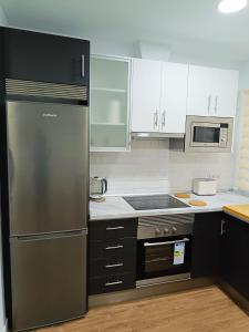 a kitchen with a stainless steel refrigerator and white cabinets at Apartamento Meraki in Santa Cruz de Tenerife