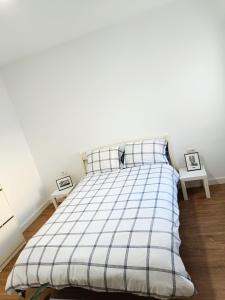 a bed in a bedroom with two tables at Apartamento Meraki in Santa Cruz de Tenerife