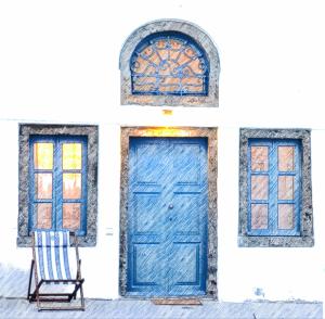 a blue door and a chair in front of a building at Whitewashed Houses in Mesaria