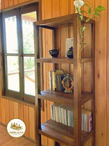 a wooden book shelf with books on a wall at Cabaña La Paz in San Andrés de Giles