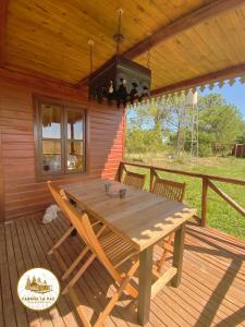 a wooden table and chairs on a wooden deck at Cabaña La Paz in San Andrés de Giles