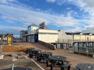 een groep picknicktafels voor een pier bij Angel Cottage in Bishopsteignton