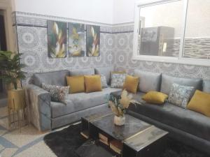 sala de estar con sofá y mesa en Appartement du lux très propre bien équipé au cœur de la ville nouvelle, en Meknès