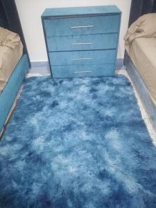 1 dormitorio con cómoda azul y alfombra azul en Appartement du lux très propre bien équipé au cœur de la ville nouvelle, en Meknès