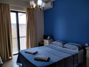una camera blu con un letto con due asciugamani di Spacious apartment in Marsalforn, Gozo a Marsalforn