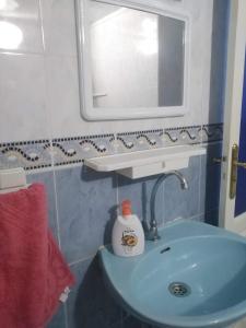 y baño con lavabo azul y espejo. en Appartement du lux très propre bien équipé au cœur de la ville nouvelle, en Meknès