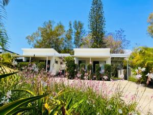 ein weißes Haus mit Blumen davor in der Unterkunft 545 Esplanade in Hervey Bay