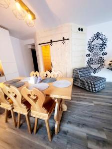 comedor con mesa de madera y sillas en 2 bedrooms appartement with enclosed garden and wifi at Koscielisko, en Kościelisko