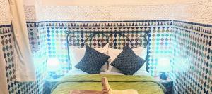 1 cama con cabecero y almohadas en Riad Essaoussan, en Marrakech