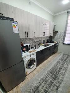 a kitchen with a washing machine and a refrigerator at Dacha 1991 in Khŭjakent