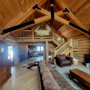 una sala de estar con sofá en una cabaña de madera en Moose Mtn Lodge/Luxury Cabin/Hot Tub/Fireplace, en Fairplay