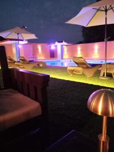 a pool with chairs and umbrellas at night at دايموند Diamond in Al-ʿUla