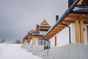 eine Reihe von Häusern mit Schnee auf dem Boden in der Unterkunft Osada Widokówka- Przystanek Podhale in Czorsztyn