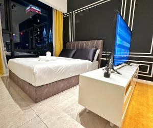 a bedroom with a bed and a desk with a television at Axon Residence By Perkasa Suites in Kuala Lumpur
