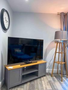 TV de pantalla plana en la sala de estar con taburete en Luxurious & Tranquil staycation - w/ Hot Tub!, en Burneside