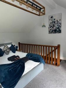 a bedroom with a bed with blue sheets and a crib at Luxurious & Tranquil staycation - w/ Hot Tub! in Burneside