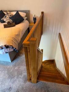 a bedroom with a bed and a wooden stair case at Luxurious & Tranquil staycation - w/ Hot Tub! in Burneside