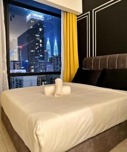 a bedroom with a large white bed with a city view at Axon Residence By Perkasa Suites in Kuala Lumpur