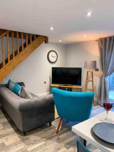 a living room with a couch and a clock on the wall at Luxurious & Tranquil staycation - w/ Hot Tub! in Burneside