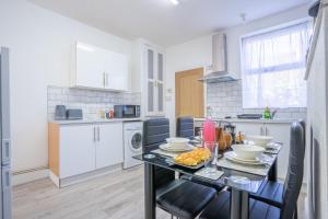 a kitchen with a table with food on it at STAYZED E - NG7 Free WiFi, Parking, Stylish House Near City Centre - Great For Tourists, Families, Contractors & Long Stays in Nottingham
