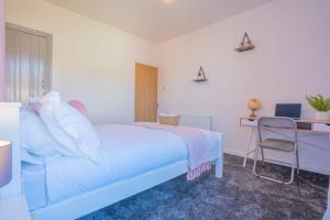 a bedroom with a bed and a desk and a chair at STAYZED E - NG7 Free WiFi, Parking, Stylish House Near City Centre - Great For Tourists, Families, Contractors & Long Stays in Nottingham