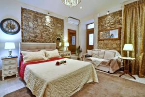 a bedroom with a bed and a stone wall at Venetian Suite Mitropolis new in Corfu