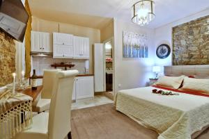a bedroom with a bed and a table and a kitchen at Venetian Suite Mitropolis new in Corfu