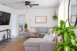 ein Wohnzimmer mit einer Couch und einem Deckenventilator in der Unterkunft Corner Casa (w Bikes!) Beach Home (3bd/2ba) in Jacksonville Beach