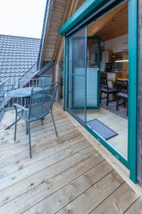 a wooden deck with a table and chairs on it at Ferienwohnung Schädel in Reichshof 