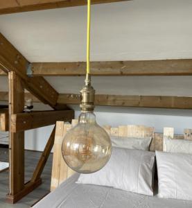 a large glass light bulb hanging over a bed at Villa K'nell - La Possession in La Possession