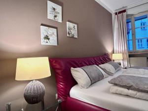 a bedroom with a red couch and a window at Ferienwohnung Adam - gemütlich und zentral auf der historischen Insel Lindau in Lindau +15 photos