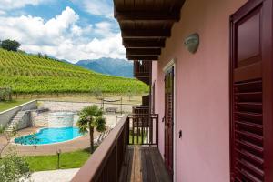 einen Balkon eines Hauses mit Poolblick in der Unterkunft Residence La Vigna in Arco