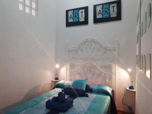 a bedroom with a white bed with blue pillows at GRH Tarraco - city center in Tarragona